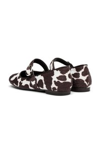Litafi cha feet chenye muonekano wa minkono ya ng'ombe rangi za mblack na white, chenye vidole vya mduara na kifungo cha kufunga juu. Nyenzo yenye texture.
