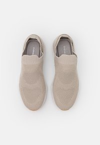 Světle béžové nazouvací boty s texturovaným pleteným svrškem, elastickým límcem a gumovou podrážkou. Obsahují hexagonální vzory na bocích.