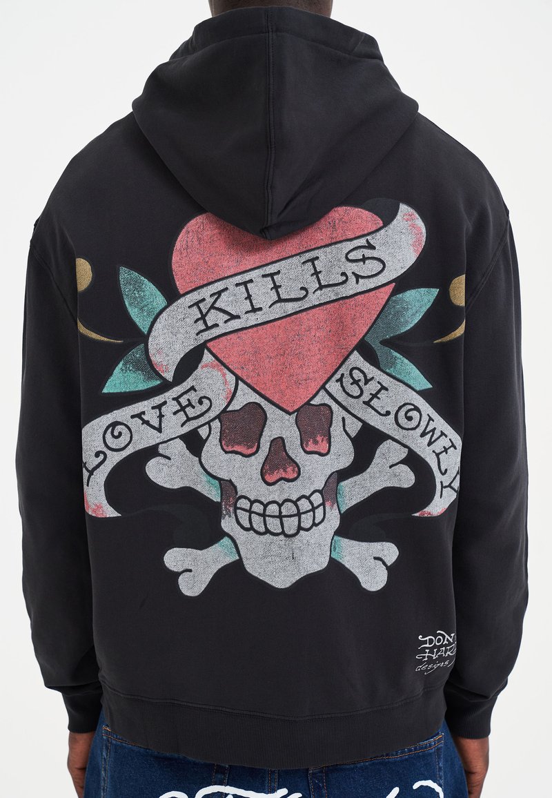 Felpa nera con cappuccio, caratterizzata da una grande grafica che presenta un teschio, un cuore e un banner con la scritta "LOVE KILLS SLOWLY". Stoffa morbida, vestibilità comoda e orlo a costine.