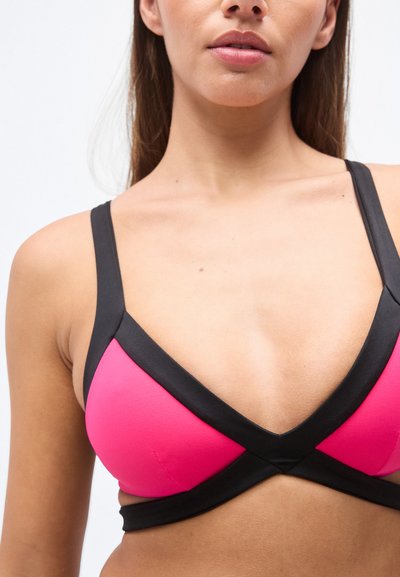 Haut de bikini rose et noir avec un design triangulaire, doté de bretelles croisées et d'une texture lisse. Contraste de couleurs notable le long des bords.