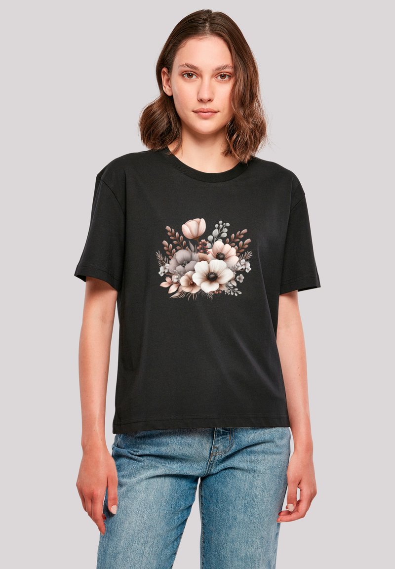 Black short-sleeve t-shirt featuring a floral graphic print in soft colors, with a round neckline and relaxed fit. Worn with light blue jeans.