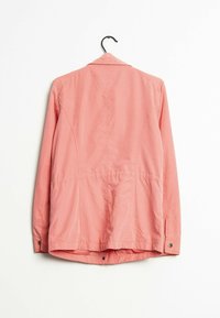 Giacca rosa chiaro realizzata in un tessuto misto cotone, con un design sartoriale, maniche lunghe e bottoni a pressione sui polsini. La parte posteriore presenta dettagli di cucitura discreti.