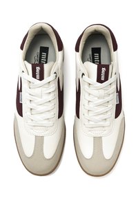 Weiße und kastanienbraune Sneakers im Retro-Stil mit strukturiertem Finish, ausgestattet mit einer Gummisohle, Schnürsenkeln und Branding auf der Zunge und der Seite.