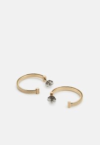 Pendientes de aro en tono dorado con textura trenzada, acentos cuadrados y un diseño de flor en tono plateado en la parte trasera para un cierre seguro.
