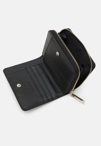 Black leather wallet with zip closure, featuring multiple card slots, a snap button, and gold-tone hardware accents inside. Logo embossed.