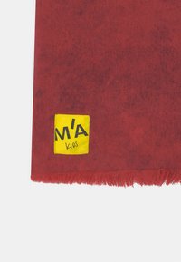 Cachecol vermelho com um acabamento texturizado, apresentando um rótulo amarelo com o texto preto "M'A Kios" em um dos cantos e bordas franjas.