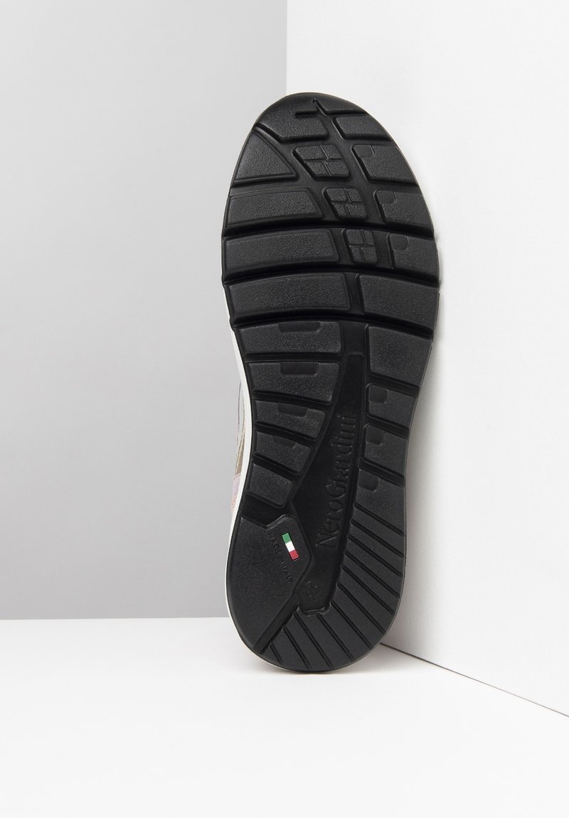 Suola in gomma nera con un motivo di battistrada multidirezionale, caratterizzata da un logo in rilievo e un piccolo dettaglio della bandiera italiana.