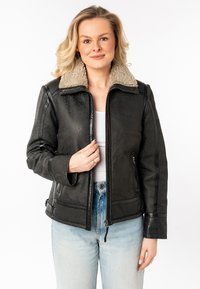 Zwarte leren jas met een beige imitatiebont kraag, ritssluiting en zijzakken. Kenmerkt zich door een gestructureerd ontwerp en textuurmateriaal.