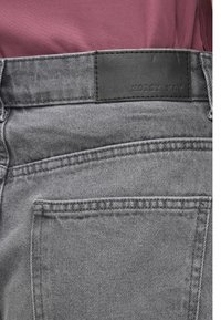 Τα γκρι τζιν από τζιν ύφασμα διαθέτουν δερμάτινο ταμπελάκι με την ένδειξη «NOISY MAY» στη μέση, με απλή λεπτομέρεια στην τσέπη και κλασικές ραφές.