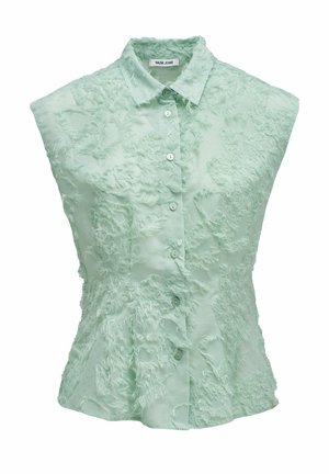 Blusa sin mangas de color verde pálido con botones y cuello, que presenta patrones texturizados de flecos y una cintura ligeramente entallada.