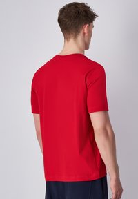 Rode katoenen t-shirt met een ronde hals, korte mouwen en een rechte zoom. Zachte textuur en klassieke pasvorm, geschikt voor casual dragen.