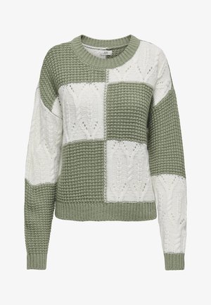 Kootud pullover-sviiter oliivrohelises ja valges, millel on kirjud mustrid tekstuursete ketramise mustrite ja soonikute otstes.