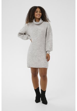 Světle šedé pletené šaty s rolákem, texturovaným vzorem a nabíranými rukávy. Stylizováno s černými kotníkovými botami.