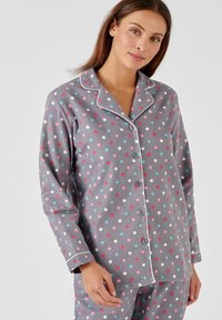 Grijs pyjama set met stippen, versierd met kleurrijke stippen in rood, blauw en wit. Zachte stof met een knoopsluiting en details van piping bij de kraag.