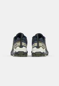 Trail running shoes with a mesh and textile upper, featuring dark blue and olive green colors, textured surfaces, and reinforced heel support.