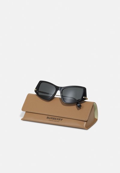 Burberryn aurinkolasit mustalla muovikehyksellä ja harmailla linsseillä, lepäävät vaaleassa nahkakotelossa, jossa on painettuna "Burberry, London England."