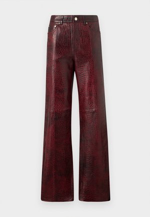 Pantaloni a gamba larga realizzati in pelle con stampa a crocodile di colore rosso intenso, dotati di chiusura frontale con bottone e due tasche laterali.