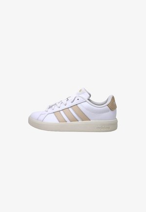 Scarpa da ginnastica Adidas bianca con strisce beige, lacci e linguetta sul tallone, vista laterale su sfondo bianco.