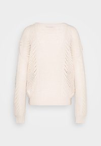 Krämfärgad stickad tröja med långa ärmar och chevronmönstrad öppet stickad design på ärmarna och frampanelen.