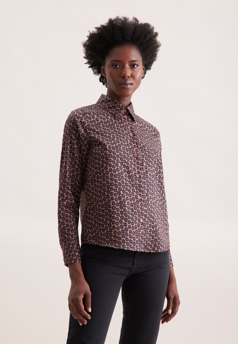 Camicia a maniche lunghe in tessuto marrone scuro con motivo floreale nei toni del rosa e dell'arancione; presenta una chiusura con bottoni e colletto.