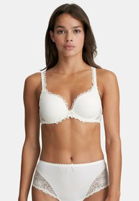 White lace-trimmed bra with padded cups and adjustable straps; matching white briefs feature floral lace accents and a bow detail.