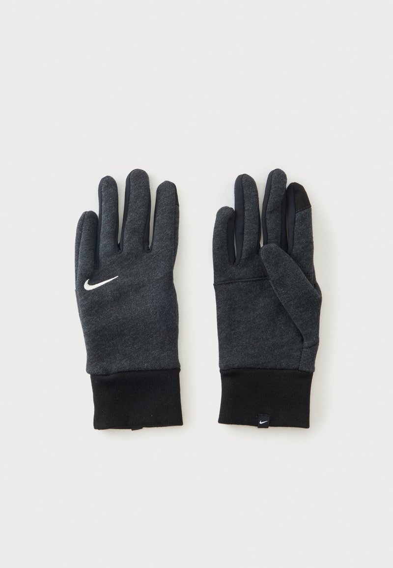 Ζευγάρι σκούρα γκρι γάντια Nike με μαύρες μανσέτες, συμβατά με οθόνες αφής άκρα δακτύλων και λογότυπα Nike swoosh σε λευκό στα χέρια και στην ετικέτα.