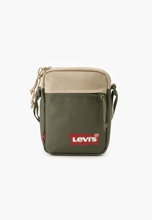 Zielono-beżowa torba na ramię wykonana z tkaniny, z przednią kieszenią wyposażoną w czerwone logo Levi's, zamknięciem na sznurek oraz regulowanym paskiem.