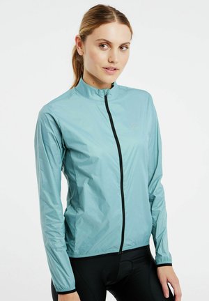 Lightweight turquoise jacket with a high collar, full front zipper, and long sleeves. Features a subtle logo and a smooth, shiny texture.