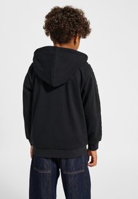 Schwarzer Kapuzenpullover mit entspannter Passform und strukturiertem Stoff, mit seitlichen Akzenten und gerippten Bündchen. Die Rückansicht zeigt ein schlichtes Design.