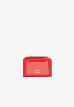 Red leather wallet with a contrasting pink panel, gold logo, and a zip closure. Textured surface with simple design and no additional accents.