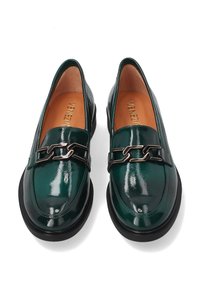 Zelené lakované mokasíny s elegantním designem, černou gumovou podrážkou a dekorativním řetízkem na svršku.