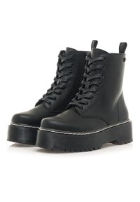 Botas de tobillo negras con cordones, con una suela de plataforma gruesa, material de cuero suave y un acento de costura blanca a lo largo del borde.