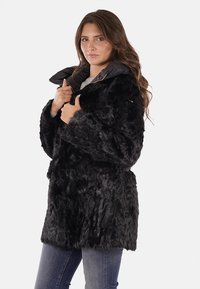 Cappotto in ecopelle nera con cappuccio staccabile grigio scuro, dotato di zip frontale e due tasche laterali, dall'aspetto strutturato e morbido.