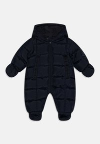 Námořnický modrý zateplený snowsuit s kapucí, předním zipem a elastickými manžetami. Hladká textura s vertikálním prošíváním. Dvě přední kapsy.