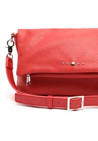 Red leather handbag with a textured finish. Features a zippered pocket, star and metal stud accents, and an adjustable strap with a buckle.