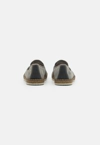 Slipper mit einem grauen und schwarzen Canvas-Obermaterial, kontrastierenden Lederrand, gewebter Jute-Zwischensohle und gummierter Sohle für Langlebigkeit.