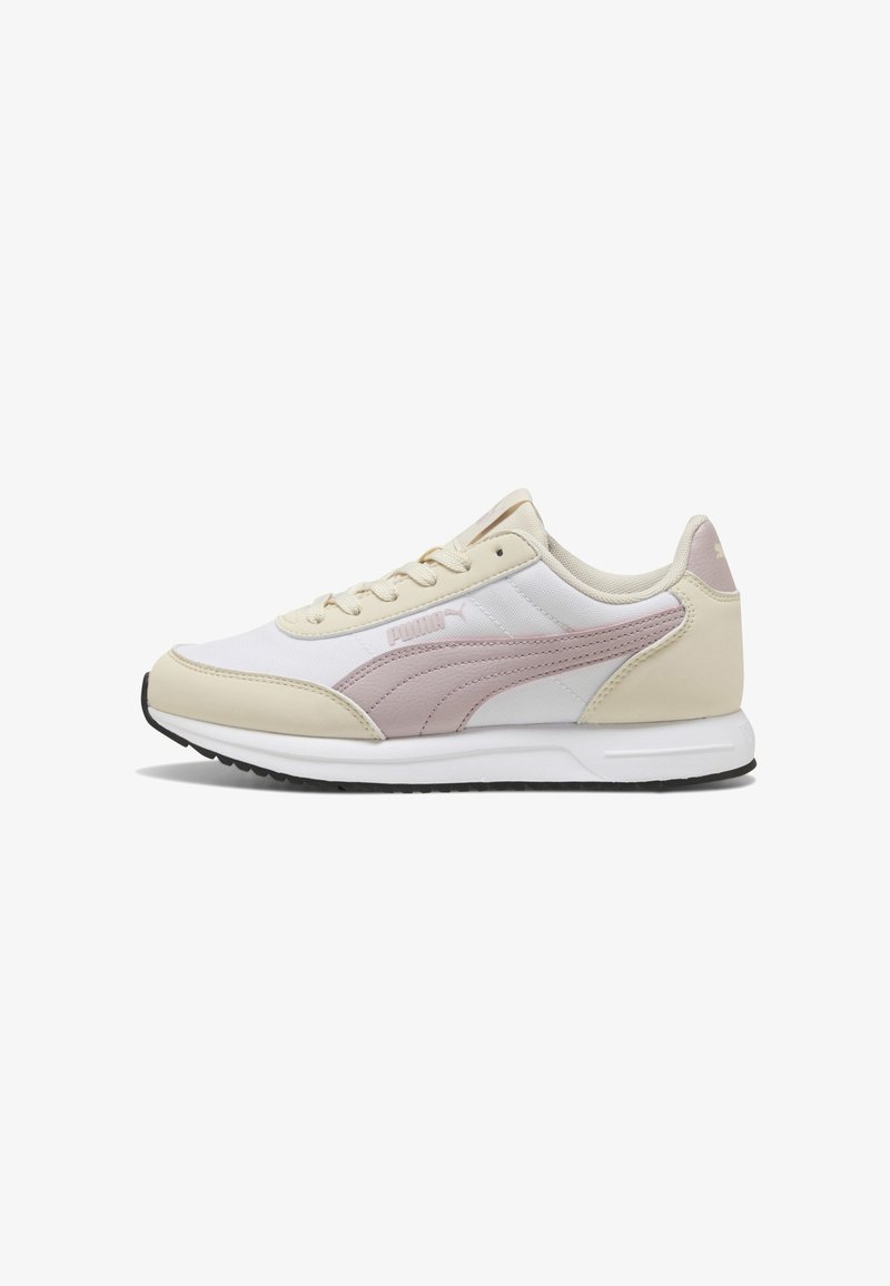Baskets Puma profil bas blanches avec des accents crème et rose clair et une semelle en caoutchouc noir, montrées de côté extérieur.