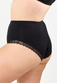Svarta bomullsshorts med hög midja och volangspetsdetalj vid benöppningarna, med en slät yta och figurnära design.