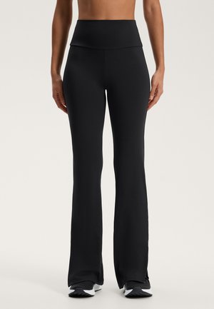 Zwarte flared leggings van glad, elastisch materiaal met een hoge tailleband, met een strakke uitstraling en zonder zichtbare patronen of accenten.