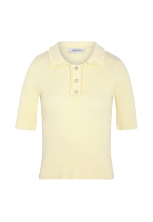 Haut jaune pâle à manches courtes côtelé avec col à volants et trois boutons décoratifs en forme de fleur sur la patte de boutonnage avant.