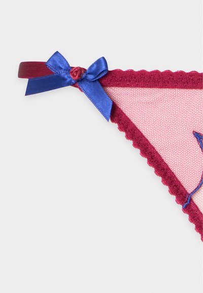Gros plan d'une lingerie rose transparente avec une bordure en dentelle bordeaux et un nœud en satin bleu décoratif sur un côté.