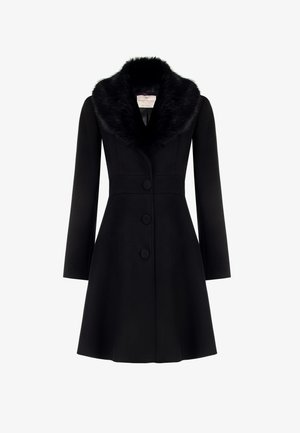 Cappotto nero con colletto di pelliccia, silhouette strutturata, vita aderente e tre bottoni rivestiti di tessuto. Maniche lunghe e fondo svasato.