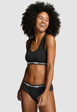 Schwarzer Sport-BH mit breitem elastischem Bund und Logo; passende schwarze Panties mit Logo-Bund. Glattes, dehnbares Material, einfaches Design.