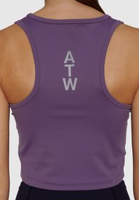 Fioletowy sportowy top z krótkim rękawem i konstrukcją typu racerback. Posiada gładką fakturę oraz nadrukowane w srebrnym kolorze logo "ATW" z tyłu.