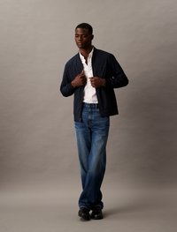 Marine bomberjack, witte blouse, blauwe wijde jeans, zwarte schoenen; gladde stof, ontspannen pasvorm, minimale details, casual ontwerp.