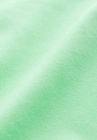Lichtgroene textuurstof met een glad oppervlak, voorzien van een subtiel patroon en een zachte val, geschikt voor kleding of stoffering.