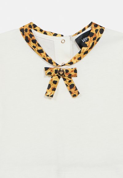 Λευκό πουκάμισο με γιακά σε λεοπάρ σχέδιο και λεπτομέρεια φιόγκου, με διακοσμητικό κουμπί σε χρυσή απόχρωση. Απαλή υφή και καθαρός σχεδιασμός.