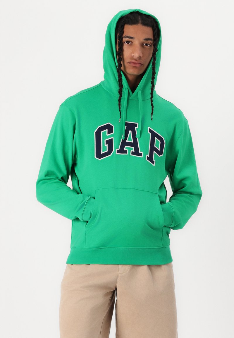 Gr üne Kapuzenjacke mit "GAP"-Logo in Marineblau. Verfügt über eine Fronttasche und eine verstellbare Kapuze. Hergestellt aus weichem Material mit langen Ärmeln.