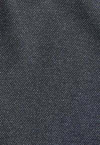 Dunkelblaues Gewebe mit feinem, strukturiertem Muster. Zeigt ein Gewebe aus kleinen geometrischen Formen, das ein haltbares und strukturiertes Erscheinungsbild vermittelt.
