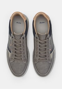 Gray sneaker with a textured upper, navy mesh accents, and beige inner lining. Features cream stitching and a logo near the laces.